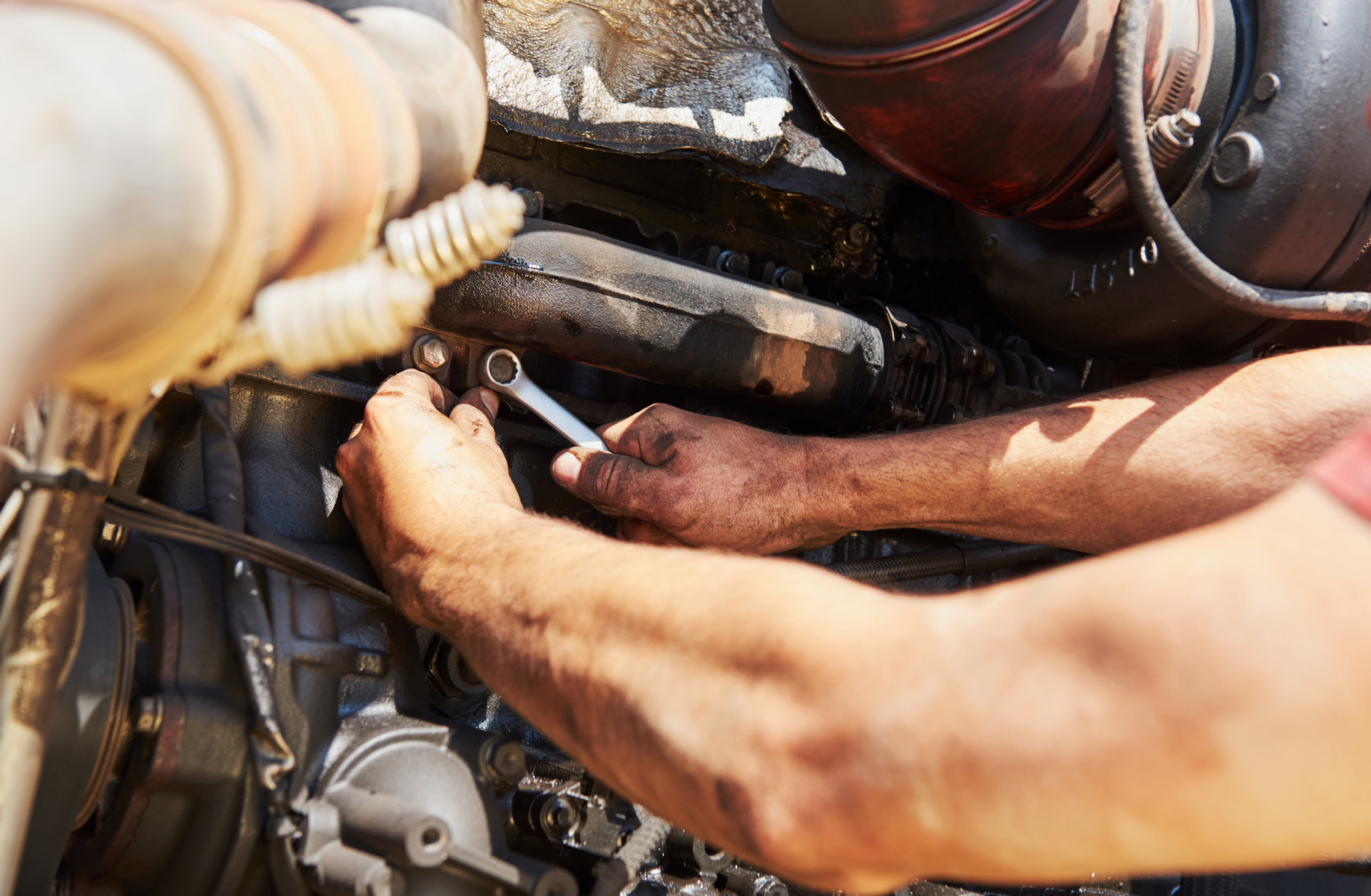Combine machine service, mechanic repairing motor outdoors